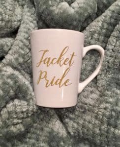 White mug stating "Jacket Pride"